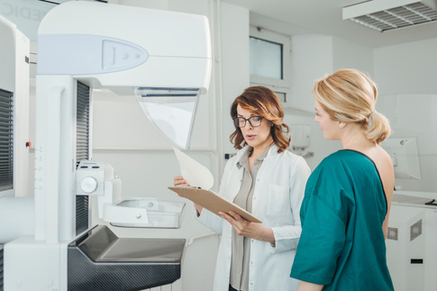 A doctor preparing a patient for a mammogram. 
