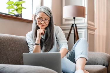 An older woman uses a healthcare navigation solution on a laptop at home. 
