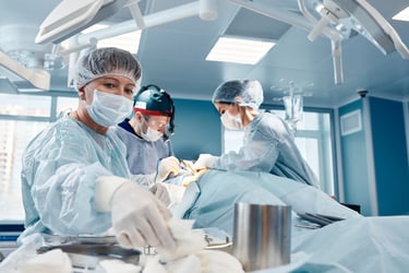 Three surgeons work together on a surgery in an operating room. 