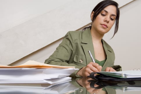 A female employee calculates her annual healthcare costs while sitting at a table. 
