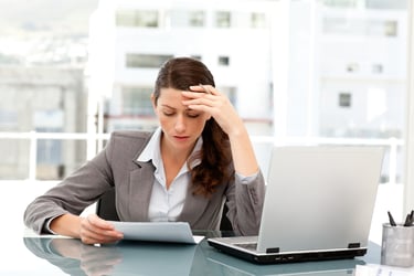 A frustrated women reviews compliance errors in an office. 