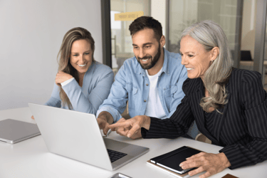 Three TPAs reviewing data on a laptop together. 
